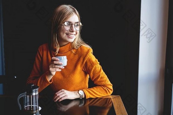 年轻的美丽的女人喝杯时尚的城市咖啡馆