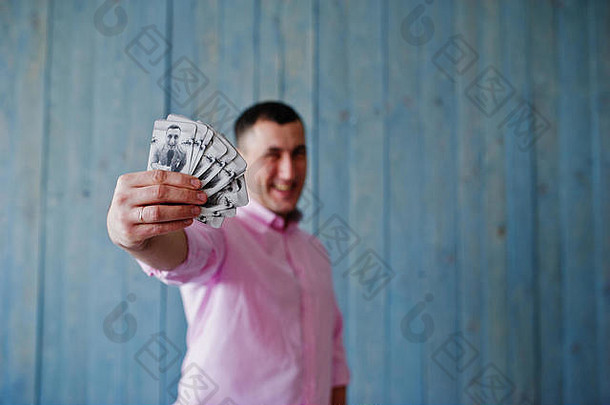 工作室肖像男人。粉红色的衬衫木背景显示卡片