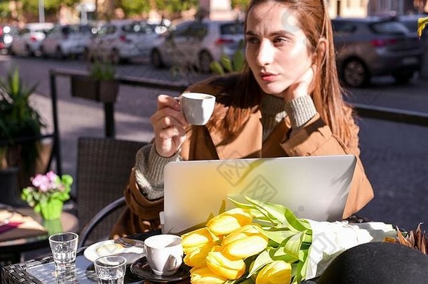美丽的年轻的女孩街咖啡馆电脑表格早餐咖啡商店工作距离<strong>自由旅<strong>游</strong>概念花束黄色的郁金香表格复制空间