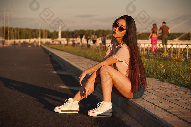 亚洲女孩短裤坐着抑制热阳光明媚的一天