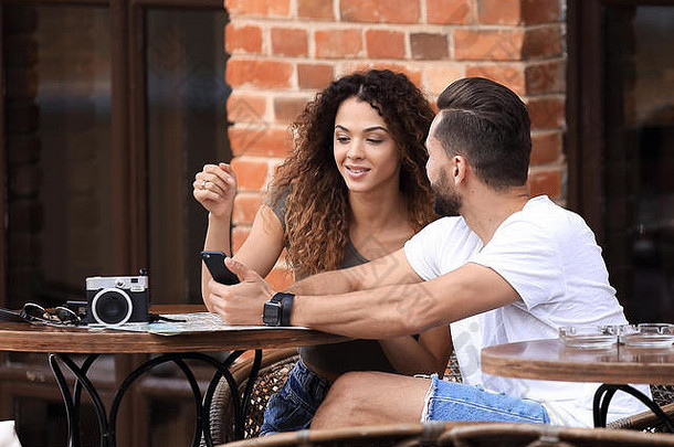 肖像年轻的夫妇坐着咖啡馆阳台