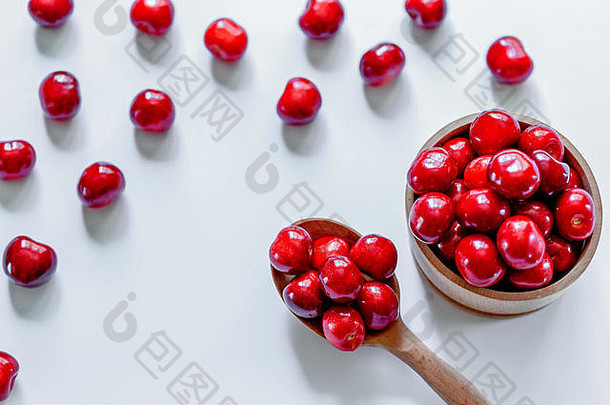 红色的成熟的<strong>樱桃</strong>木勺子白色背景平躺食物概念