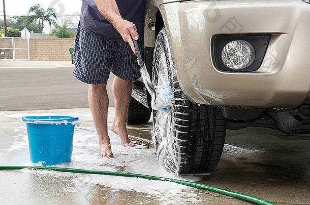 男人。洗车肥皂刷清洁轮胎轮子车辆