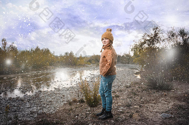 美丽的金发碧眼的女孩羊毛毛衣帽美丽的秋天景观河背景
