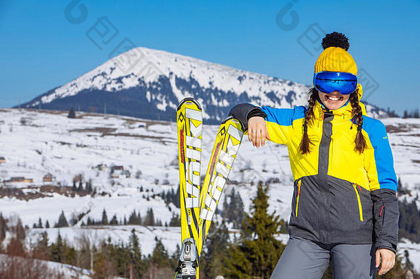 年轻的微笑漂亮的女人持有<strong>滑雪</strong>山背景