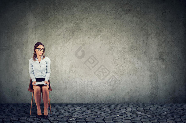 年轻的女人坐着椅子纸等待工作面试紧张