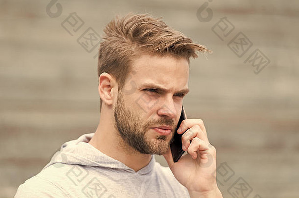 男人。胡子走智能手机城市背景楼梯男人。胡子脸说话智能手机的家伙集中回答调用智能手机沟通概念