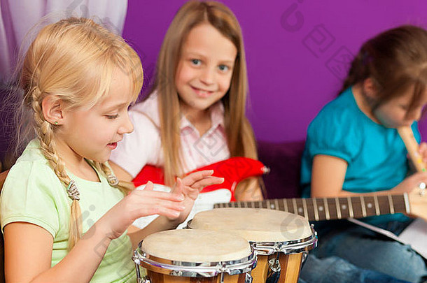 孩子们姐妹使音乐练习玩吉他邦戈长笛