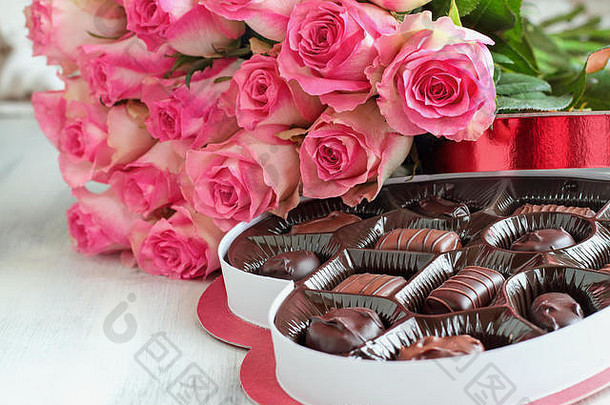 打软粉红色的玫瑰花心形状的盒子巧克力糖果情人节一天木背景
