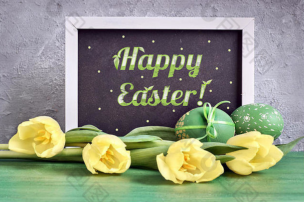 黑板上标题快乐复活节装饰黄色的郁金香绿色复活节鸡蛋灰绿背景