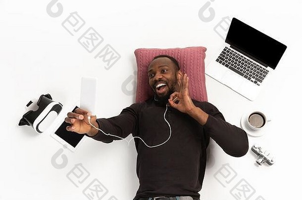 年轻的非裔美国人男人。设备小工具孤立的白色工作室背景概念现代技术小工具科技情绪Copyspace游戏购物会议在线教育