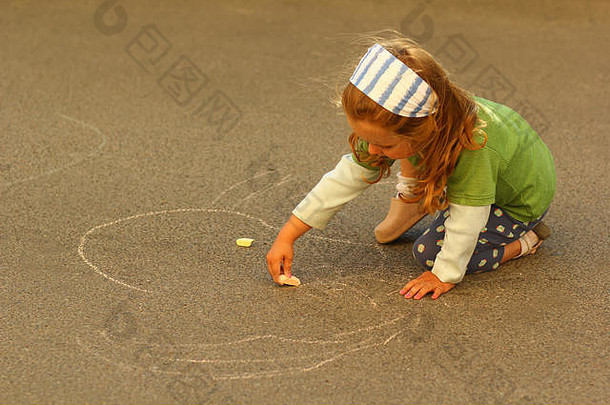 蹒跚学步的女孩画粉笔沥青