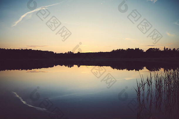 风景优美的日落反映了平静湖颜色爽肤水应用自然背景
