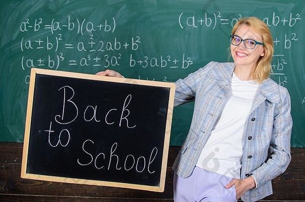 开始学校季节女人老师正式的西装持有黑板上登记回来学校夫人教育家教室准备学校一年老师通知开始教育
