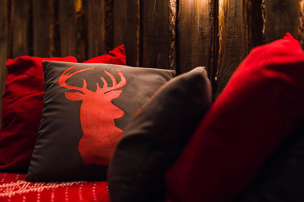 鹿头红色的手使枕头木背景室内