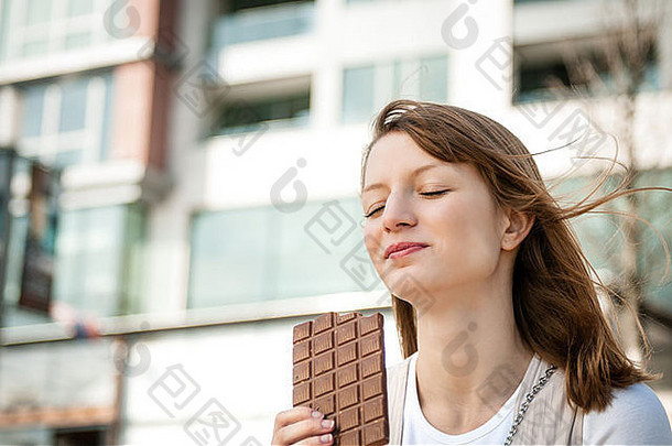 肖像年轻<strong>的</strong>美丽<strong>的</strong>女人吃巧克力生活方式户外图像