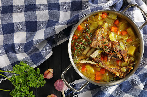 美味的冰岛羊肉冬天热汤蔬菜香料克约苏帕不锈钢钢砂锅锅木表格厨房毛巾