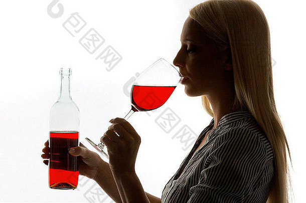 年轻的女人玻璃红色的酒酒品尝