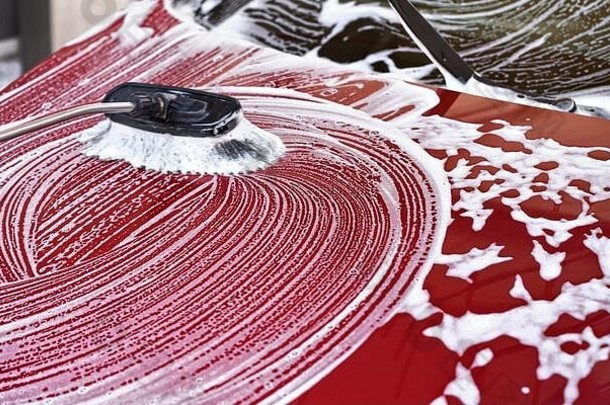 红色的车洗服务车洗刷离开中风白色肥皂泡沫前面罩清洗