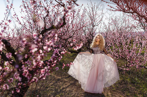 美丽的女人长衣服花园盛开的桃子