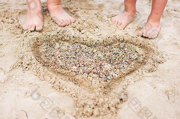 心形状使沙子鹅卵石孩子们脚