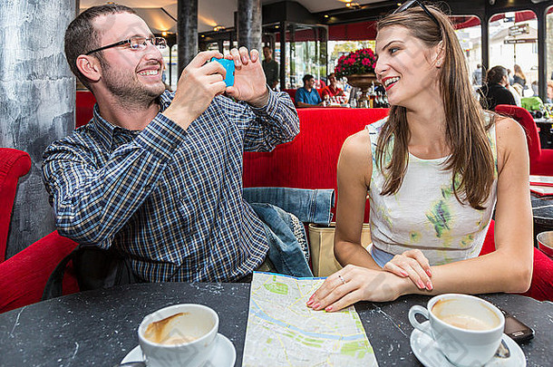 年轻的快乐夫妇采取<strong>照</strong>片移动电话巴黎咖啡馆