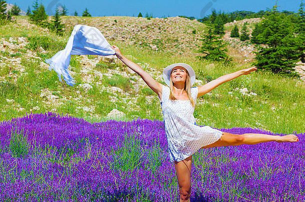美丽的年轻的女人跳舞紫色的薰衣草场穿时尚的白色他衣服持有手披肩