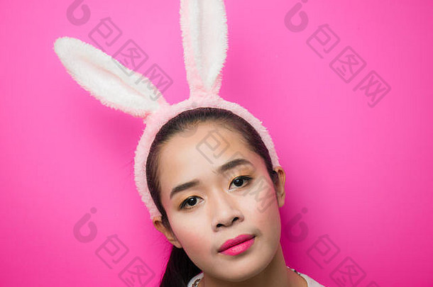 可爱的十几岁的女孩穿兔子耳朵头巾粉红色的背景女人穿兔子耳朵头巾复活节有吸引力的年轻的女人斯米利
