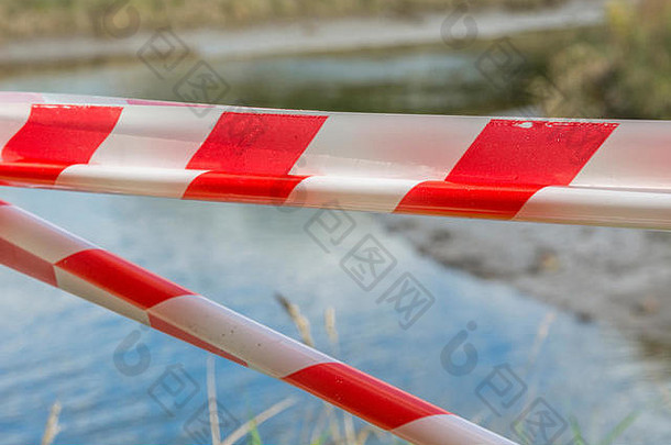 红色的白色警告障碍磁带河比喻危害危险谨慎