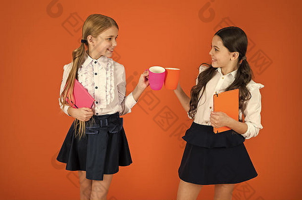 喝茶打破学校伴侣放松喝享受学生女孩孩子们学校统一的橙色背景女学生持有<strong>书记</strong>事本杯子学校例程打破放松