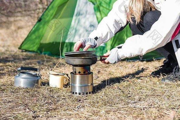 野营烹饪女人徒步旅行者烹饪午餐前面帐篷自然