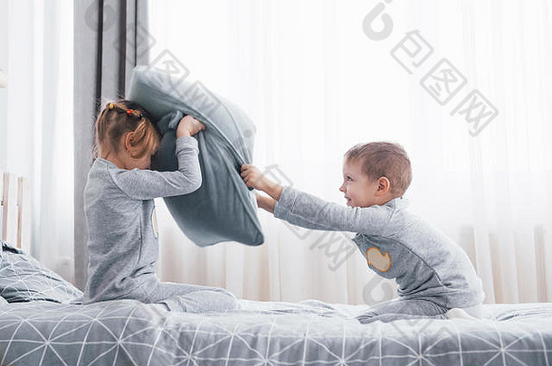 男孩女孩上演了枕头战斗床上卧室淘气的孩子们击败枕头种<strong>类游戏</strong>