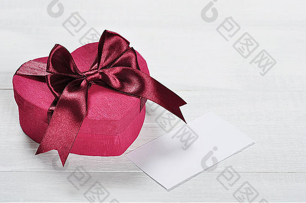 心形状的粉红色的情人节一天礼物盒子白色木背景