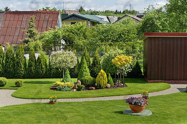 部分理想的欧洲装饰农村花园绿色草坪上花灌木阳光明媚的一天夏天景观