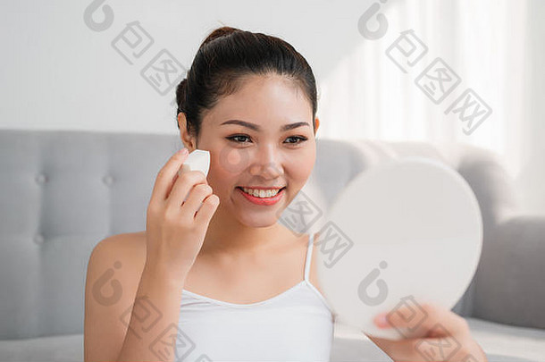 美丽的亚洲女人化妆品海绵脸镜子首页