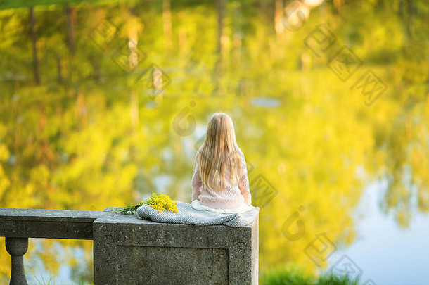 回来年轻的金发碧眼的女孩坐亭石头栅栏码头面对湖视图看日落夏天时间复制空间孤独