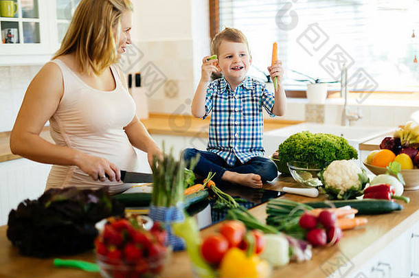 怀孕了女人准备餐儿子新鲜的蔬菜