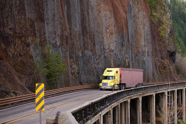 黄色的阀盖美国大钻井平台半卡车携带货物长宽敞的散装半预告片绕组危险的路岩石墙桥坡
