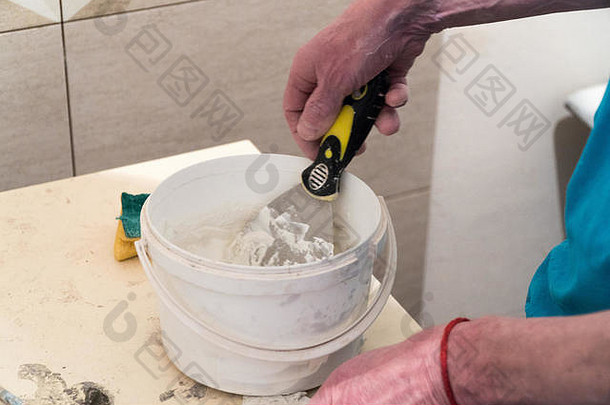 工人准备桶腻子瓷砖接缝完成作品技术铺设瓷砖
