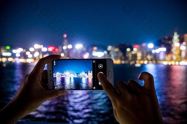 女人移动电话照片城市视图晚上光背景