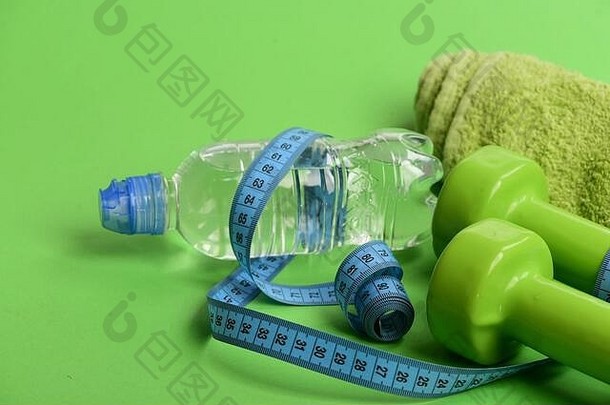 体育运动重量损失概念哑铃明亮的绿色颜色毛巾磁带水瓶绿色背景体育政权符号磁带测量青色颜色塑料杠铃
