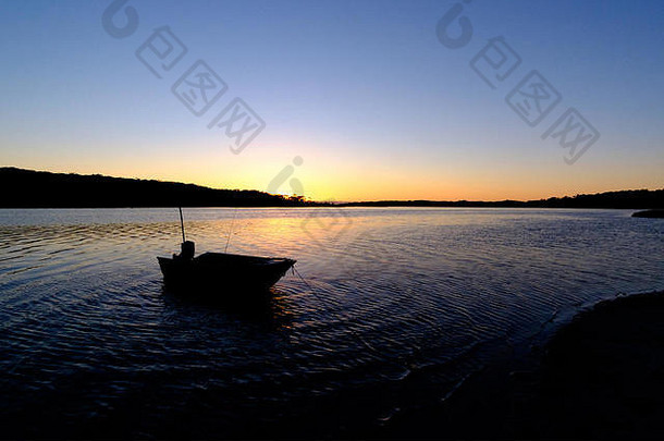 小船轮廓锚定水的边缘日出和平潮汐入口
