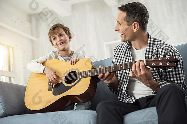 快乐的男孩父亲玩吉他