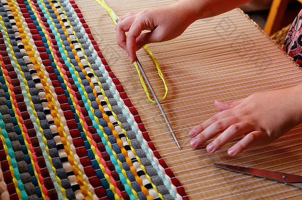 女人手编织手工制作的地毯