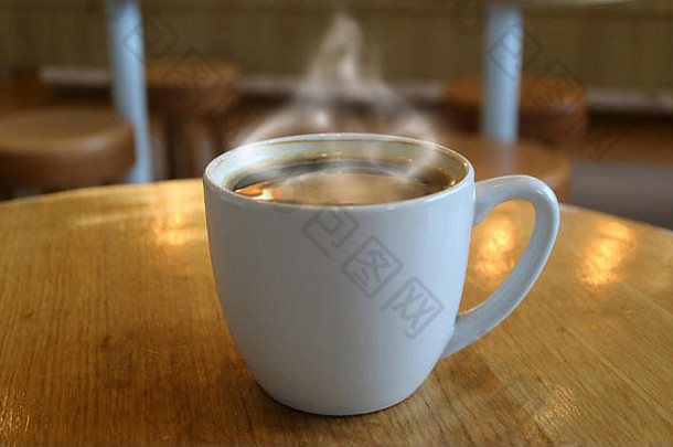 杯热咖啡烟轮木表格模糊背景