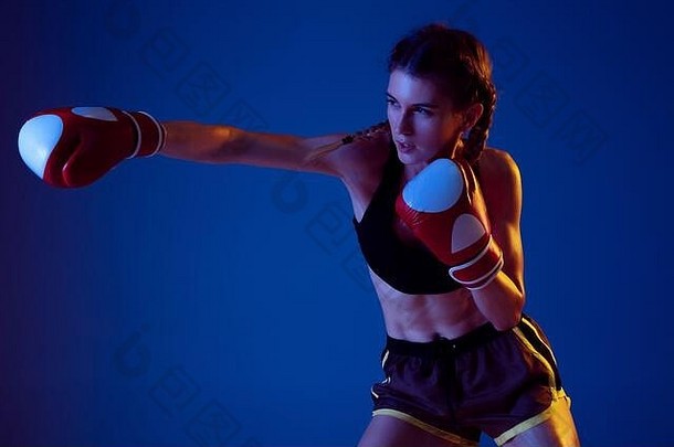 战斗适合高加索人女人运动服装拳击蓝色的工作室背景霓虹灯光novice女高加索人拳击手工作培训体育运动健康的生活方式运动概念