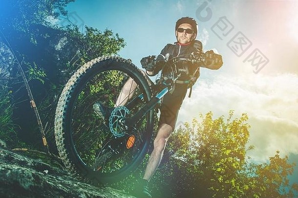 极端的自行车骑体育运动高加索人骑摩托车的人山自行车骑岩石