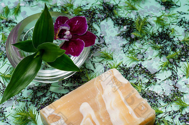 手工制作的ultra-moisturizing杏仁有香味的山羊牛奶酒吧肥皂装饰竹子兰花花绿色背景