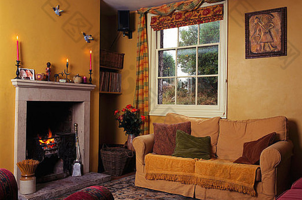 黄色的沙发窗口小黄色的economy-style生活房间点燃火壁炉