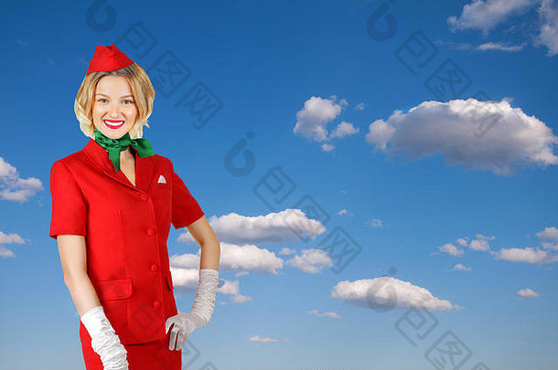 肖像迷人的空姐穿红色的统一的天空背景